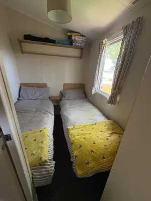two beds in a small room with a window at Lush Lake View in Millom