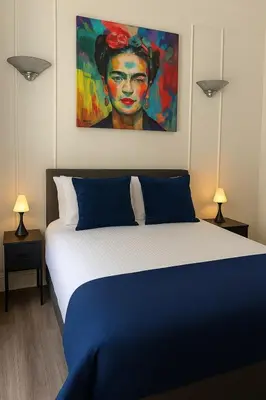 a bedroom with a bed with a painting on the wall at Trendy Penthouse, Liverpool City Centre in Liverpool