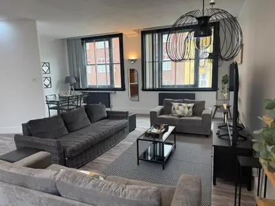 a living room with two couches and a table at Trendy Penthouse, Liverpool City Centre in Liverpool
