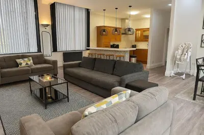 a living room with two couches and a kitchen at Trendy Penthouse, Liverpool City Centre in Liverpool