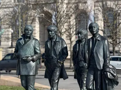 a statue of four men standing next to a building at Trendy Penthouse, Liverpool City Centre in Liverpool