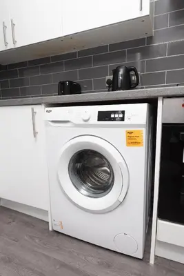 a white washing machine under a counter in a kitchen at 3-Bed Coastal Retreat in Waterloo
