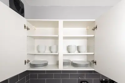 a kitchen with white shelves with dishes on them at 3-Bed Coastal Retreat in Waterloo