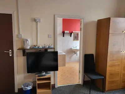 a living room with a television and a bathroom at Tulip Hotel Blackpool in Blackpool
