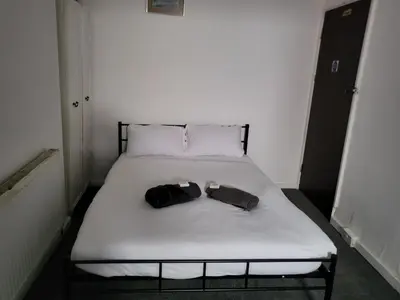 a bed with two pairs of shoes on it at Tulip Hotel Blackpool in Blackpool