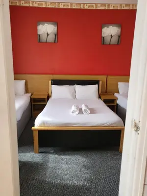 a bedroom with a bed with two shoes on it at Tulip Hotel Blackpool in Blackpool