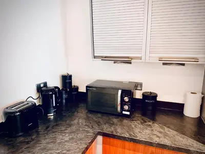 a kitchen with a counter with a microwave and appliances at Claire Stay Apartment in Liverpool