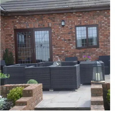 a brick building with black wicker fencing in front of it at Marsh Farm Hall in Great Eccleston