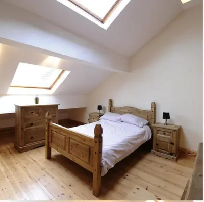 a bedroom with a bed and two night stands and a skylight at Marsh Farm Hall in Great Eccleston