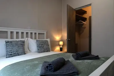 a bedroom with a bed with two towels on it at Bittern Lodge: 3BD Retreat in South Lakeland Park in Borwick