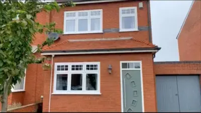 a red brick house with a white garage door at Birkdale Golf Open Holiday Home in Southport