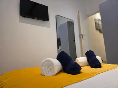 a bed with blue and white towels on it at 2 Bedroom Apartments Near Anfield Stadium - Sleeps 4 per Flat in Liverpool