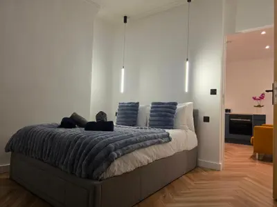 a bedroom with a large bed with blue pillows at 2 Bedroom Apartments Near Anfield Stadium - Sleeps 4 per Flat in Liverpool