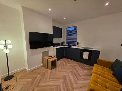 a living room with a couch and a television at 2 Bedroom Apartments Near Anfield Stadium - Sleeps 4 per Flat in Liverpool