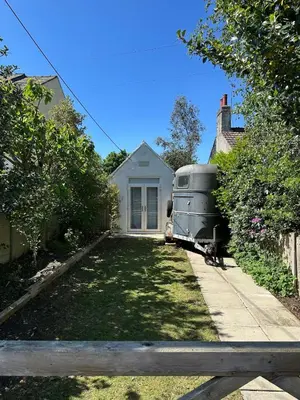 an old airstream trailer parked in front of a house at The Telephone exchange very quaint hot tub stay in Scarisbrick