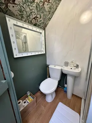 a small bathroom with a toilet and a sink at The Telephone exchange very quaint hot tub stay in Scarisbrick