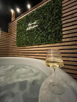 a glass of white wine sitting on a table at The Telephone exchange very quaint hot tub stay in Scarisbrick