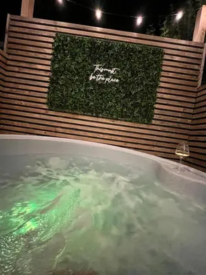 a jacuzzi tub with a sign that reads happy neighbor at The Telephone exchange very quaint hot tub stay in Scarisbrick
