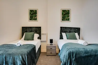 two beds in a room with green and white at Cosy Wigan Apartment with Sunny Views in Wigan