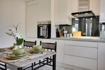 a kitchen with a table with chairs and a counter at Cosy Wigan Apartment with Sunny Views in Wigan