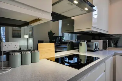 a large kitchen with a stove top oven at Cosy Wigan Apartment with Sunny Views in Wigan