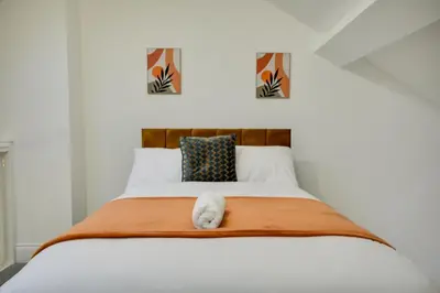 a white bed with a white stuffed animal on it at Wigan - Apartment - Sleeps 6 - Parking in Wigan
