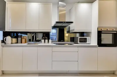 a white kitchen with white cabinets and appliances at Wigan - Apartment - Sleeps 6 - Parking in Wigan