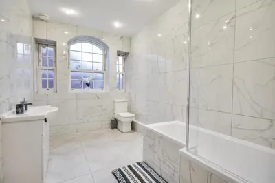 a white bathroom with a tub and a sink at Wigan - Apartment - Sleeps 6 - Parking in Wigan
