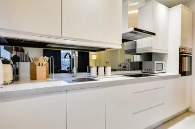 a white kitchen with white cabinets and appliances at Wigan - Apartment - Sleeps 6 - Parking in Wigan
