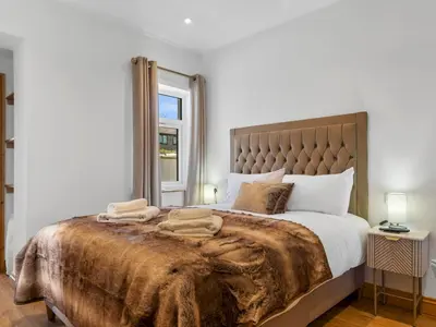 a bedroom with a large bed and a window at Newly Renovated Luxury Bungalow Pass the Keys in Ulverston