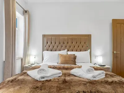 a bedroom with a large bed with towels on it at Newly Renovated Luxury Bungalow Pass the Keys in Ulverston