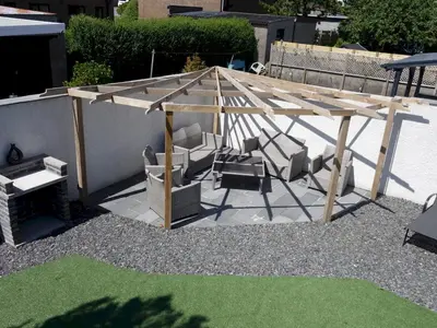a wooden pergola with two chairs and a table at Newly Renovated Luxury Bungalow Pass the Keys in Ulverston