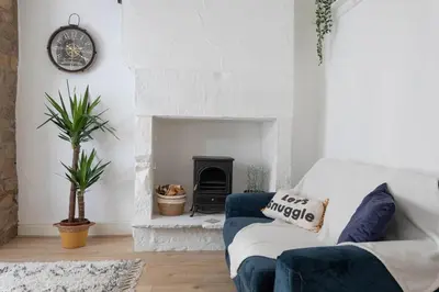 a living room with a blue couch and a fireplace at Fisherman's Cottage by the sea in Morecambe