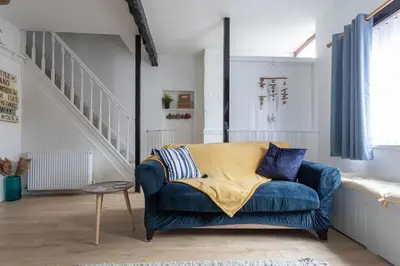 a blue couch in a living room with a staircase at Fisherman's Cottage by the sea in Morecambe
