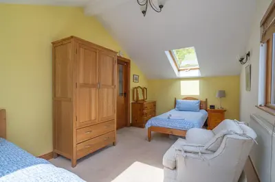 a bedroom with a bed and a dresser and a window at Leighton Banks in Beetham