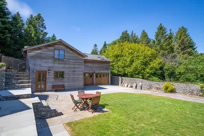 a backyard with a table and chairs and a barn at Leighton Banks in Beetham