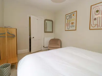 a bedroom with a white bed and a chair at 28 Rock Villas in Carnforth