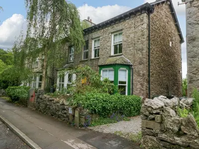 an old stone house with a green window at 28 Rock Villas in Carnforth