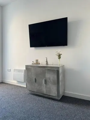 a living room with a tv on a wall at Homely stay Bootle Liverpool in Litherland