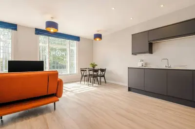 a kitchen and living room with a couch and a table at Elysée Suites - Lovely 2 Bed Flat in Southport in Southport