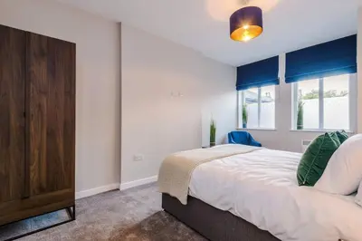 a bedroom with a bed and a dresser and a window at Elysée Suites - Lovely 2 Bed Flat in Southport in Southport