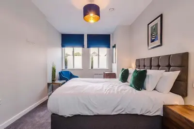 a bedroom with a large white bed with green pillows at Elysée Suites - Lovely 2 Bed Flat in Southport in Southport