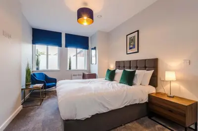 a bedroom with a king sized bed and a desk at Elysée Suites - Lovely 2 Bed Flat in Southport in Southport