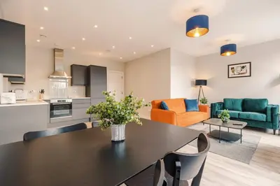 a kitchen and a living room with a dining table at Elysée Suites - Lovely 2 Bed Flat in Southport in Southport