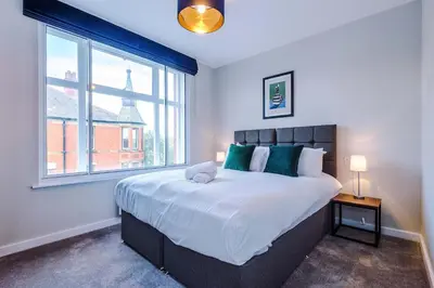 a bedroom with a large bed with a large window at Elysée Suites - Modern 1 Bed Flat in Southport in Southport