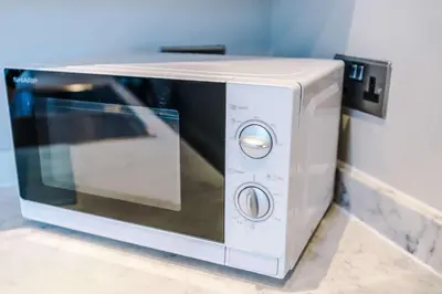 a white microwave oven sitting on top of a counter at Elysée Suites - Modern 1 Bed Flat in Southport in Southport