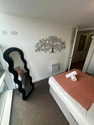 a bedroom with a bed and a tree mural on the wall at City View One Bedroom Apartment by StaySavvy Accommodation in Liverpool