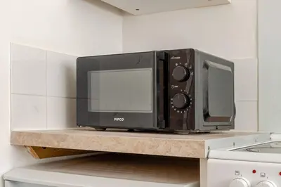 a microwave sitting on a counter in a kitchen at Olive Guest House in Bolton