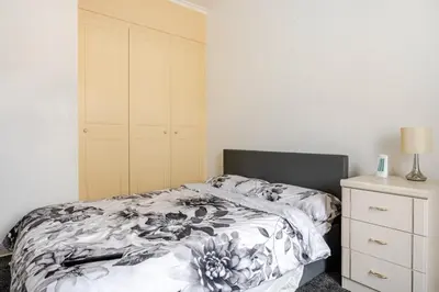 a bedroom with a bed and a dresser at Olive Guest House in Bolton
