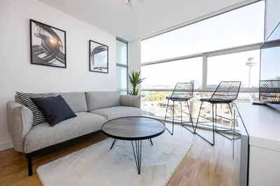 a living room with a couch and a table and chairs at Stunning Skyline Liverpool Apartment with Parking in Liverpool
